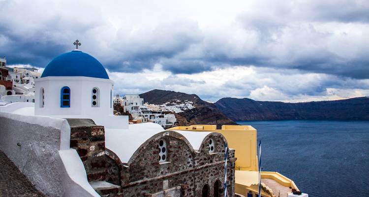 Église emblématique aux dômes bleus avec vue sur la caldeira de Santorin.