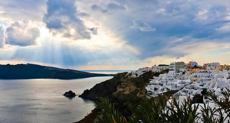 Vue de la côte de Santorin avec des maisons blanches et des nuages spectaculaires.