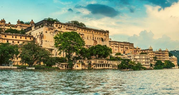 Stadspaleis langs de waterkant met weelderige groen.