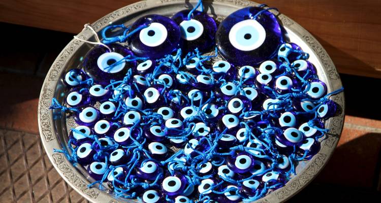 A plate filled with blue eye charms.