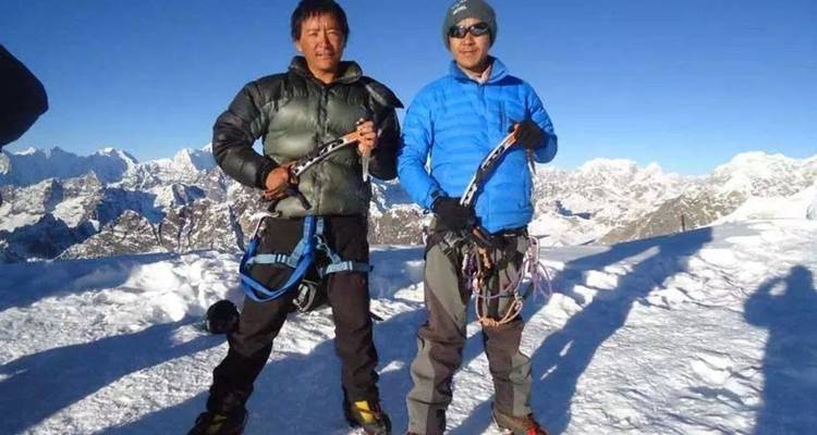 Two climbers with ice axes on a snowy mountain.