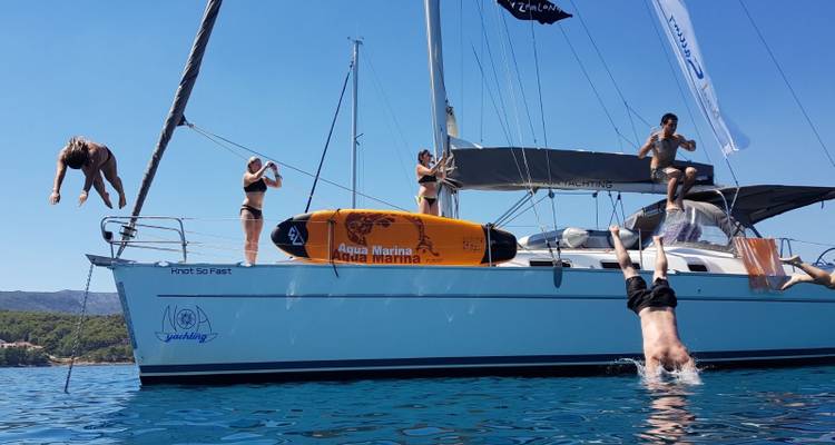 Mensen die van een jacht de zee in duiken.