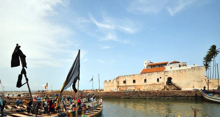 Château d'Elmina avec de petites embarcations sur l'eau.