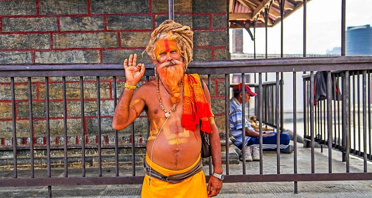 A man in colorful attire greeting with a hand gesture