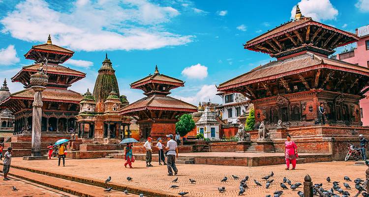 Ancient multi-tiered temples with people walking nearby