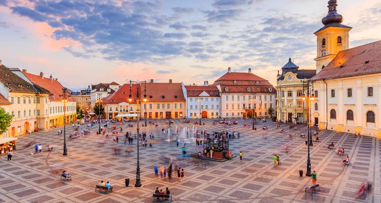 Evening view of Sibiu’s grand central square with blurred motion of people against pastel skies