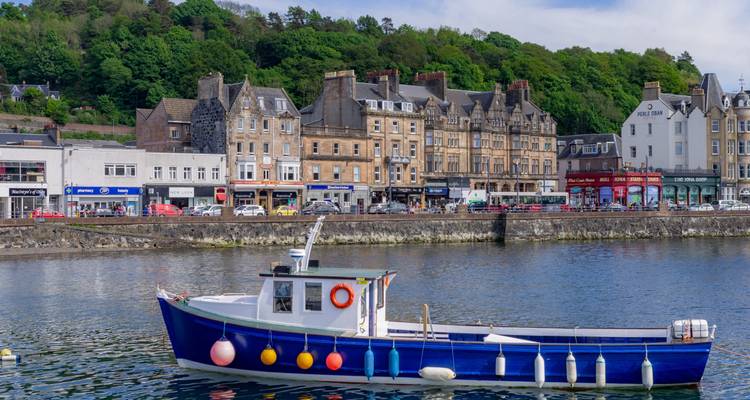 Pequeña embarcación pesquera with decoración de boyas a lo largo del malecón.