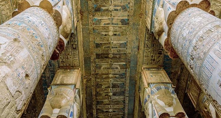 Aufwendig geschnitzte Steindecke und Säulen mit Hieroglyphen und Malereien.