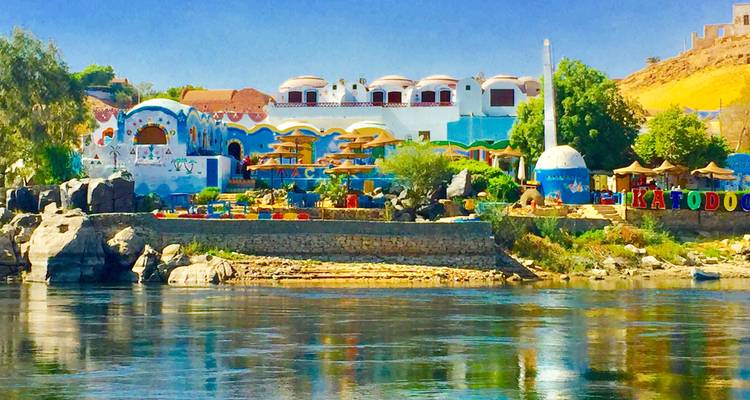 Bunte Gebäude entlang eines Flussufers bei klarem Himmel.