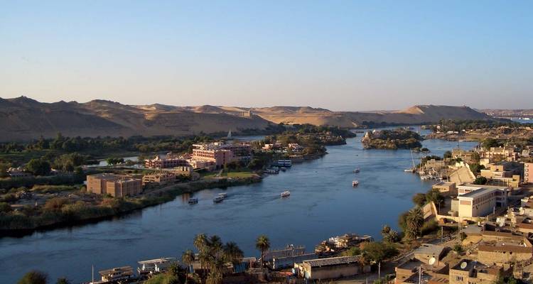 Fluss, der durch eine Wüstenlandschaft fließt mit Gebäuden entlang seiner Ufer.