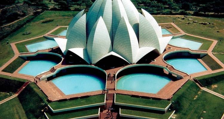 Aerial view of the Lotus Temple’s marble petals surrounded by turquoise pools and manicured lawns.