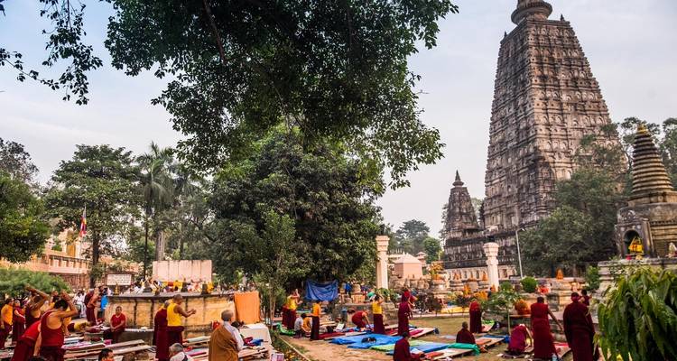Groupe de personnes devant un grand temple avec une végétation luxuriante.