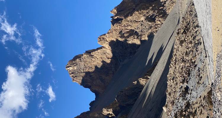 Een rotsachtige bergtop onder een heldere blauwe hemel.