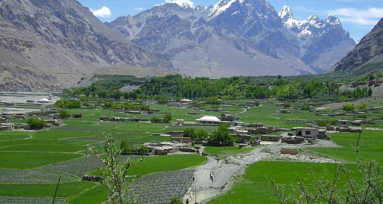 Valle agrícola verde con montañas.