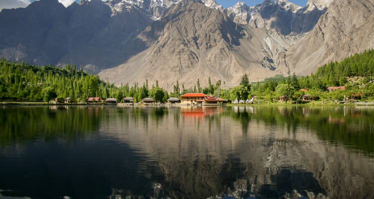 Un paisaje montañoso escénico con un reflejo en un gran lago.