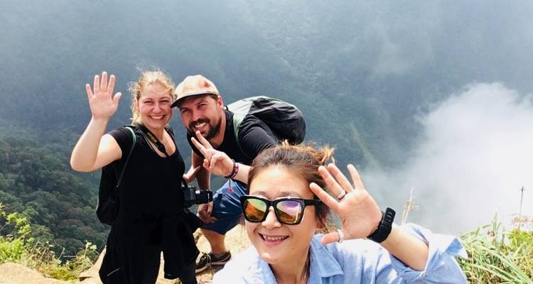Drie mensen die een selfie maken met een mistige berg op de achtergrond.