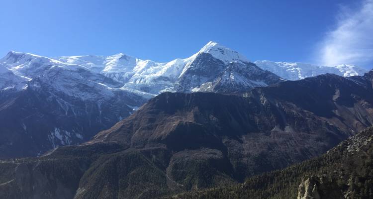 Majestic view of snow-covered mountains under a clear blue sky.