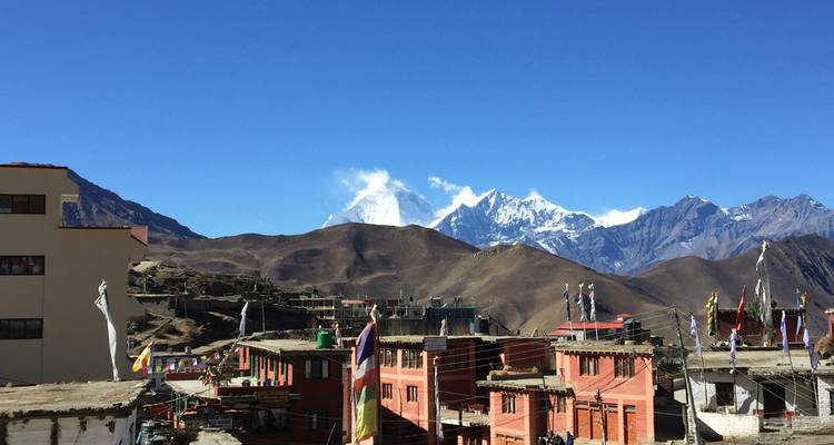 Small town with mountainous landscape in the background under clear skies.