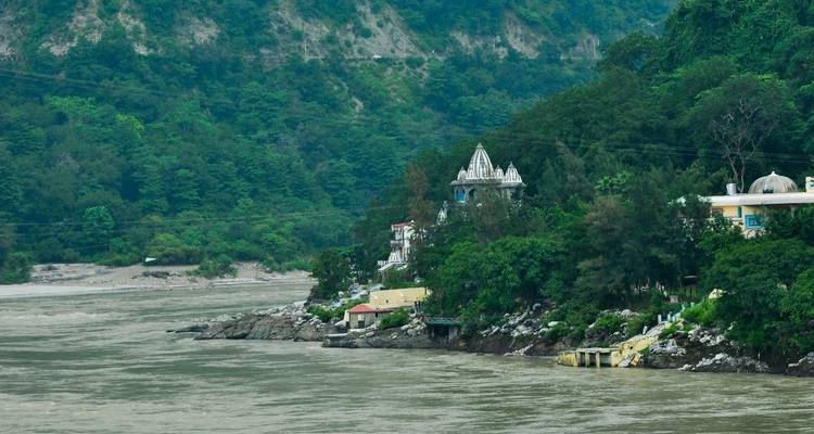 View of a riverside town surrounded by greenery.