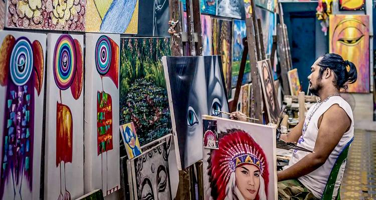 Artist painting a portrait in a vibrant and colorful art gallery.