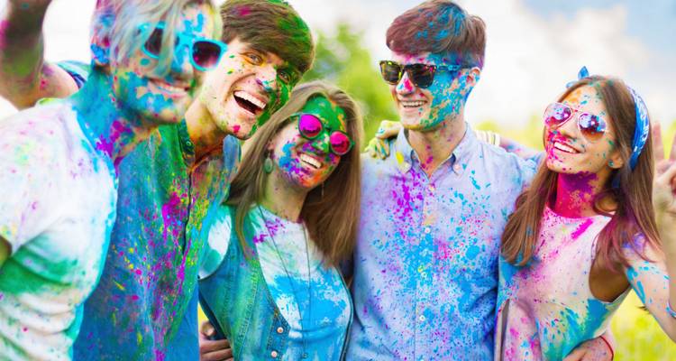 Group of people covered in colorful powder.