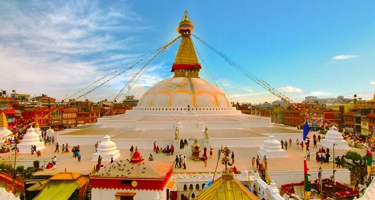 Vue du stupa de Boudhanath entouré de bâtiments.