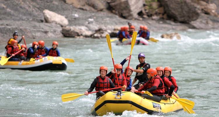 Groupe de personnes faisant du rafting sur une rivière.