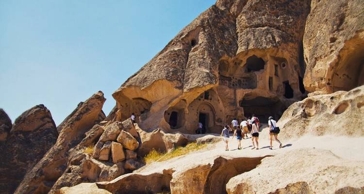 Tourists exploring the rock formations and caves of Cappadocia.