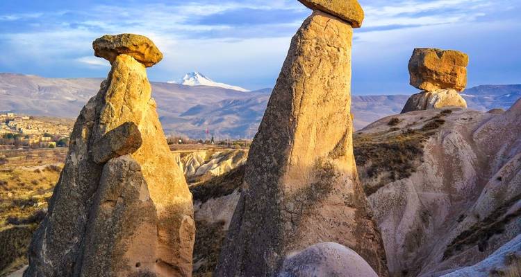 Unique fairy chimneys and rock formations illuminated by sunset.