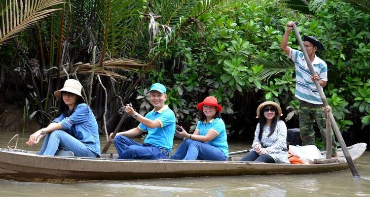Tourists enjoying a boat ride in a lush river.