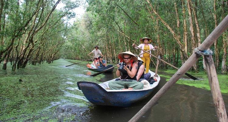 Tourists in boats along a narrow waterway.