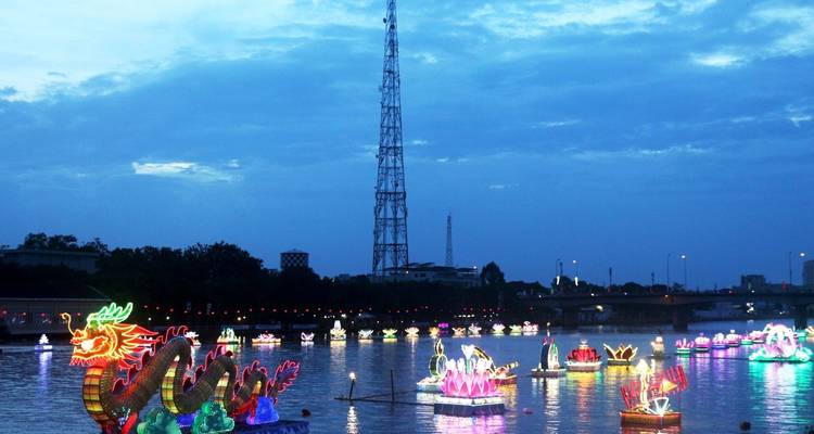 Illuminated dragon boat festival at dusk.