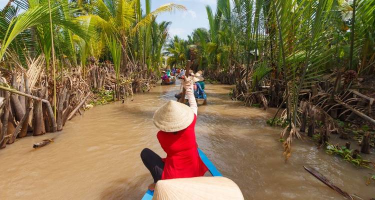 Boats paddling through a narrow river in a jungle