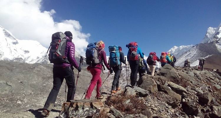 Groep trekkers met rugzakken in een rotsachtige berg.