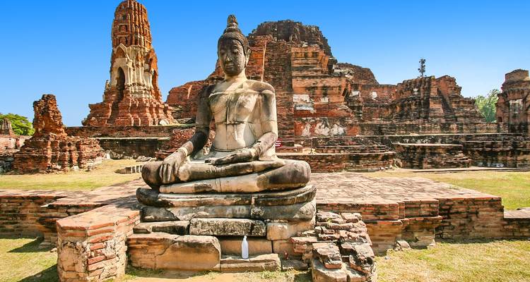 Alte Tempelruinen mit einer großen Buddha-Statue.