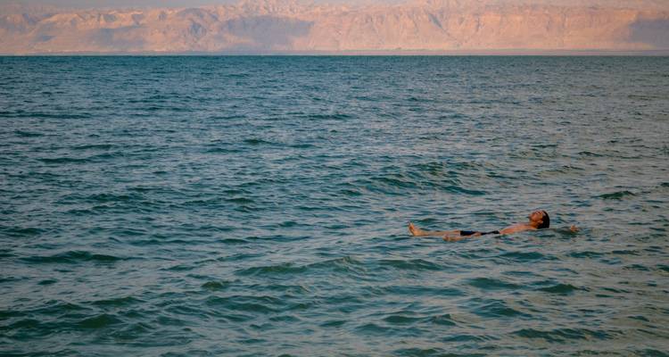 Person floating on the surface of the Dead Sea.