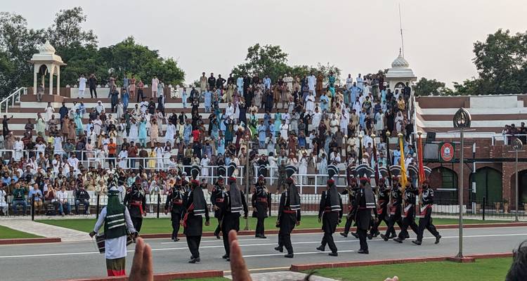 Een parade met marcherende soldaten bekeken door een menigte.