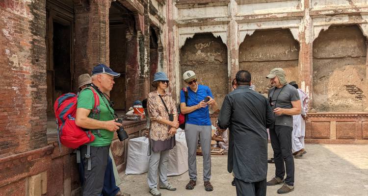 Toeristen op een historische binnenplaats, luisterend naar een gids.
