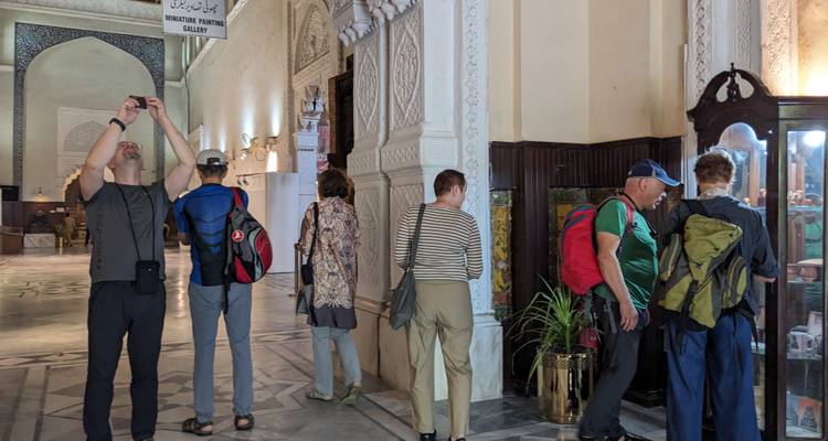 Toeristen die tentoonstellingen bekijken in een overdekte galerij.