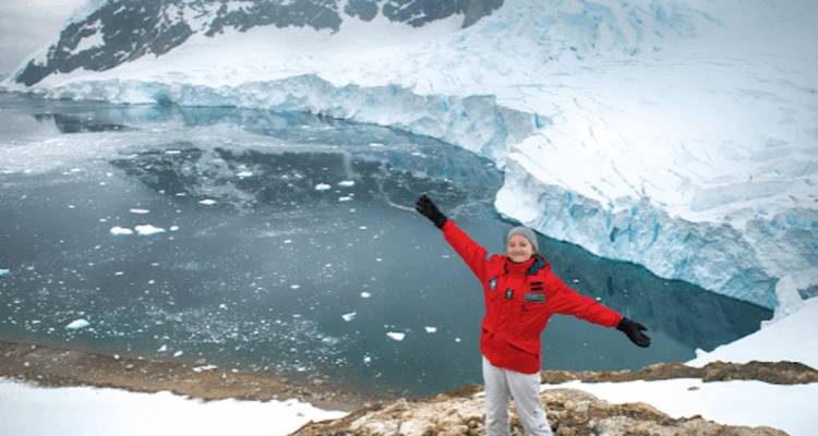 Personne posant les bras ouverts dans les montagnes enneigées de l'Antarctique.