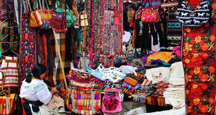 Een marktscène met felgekleurde textiel en lokale mensen.