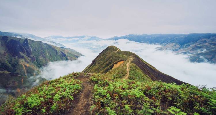 Panoramisch uitzicht op bergkammen met wolken aan de horizon.
