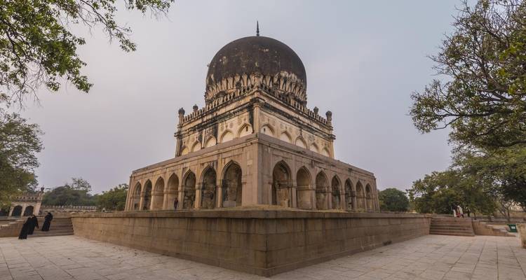Historic tomb with a domed roof in a tranquil setting.