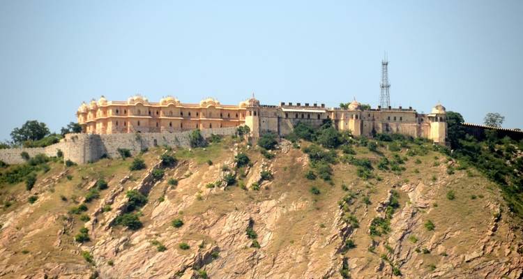 Festung auf einem Berg mit zerklüftetem Gelände darunter.