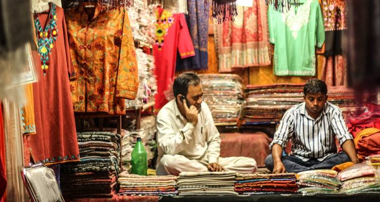 Zwei Männer in einem bunten Geschäft, das Textilien verkauft.