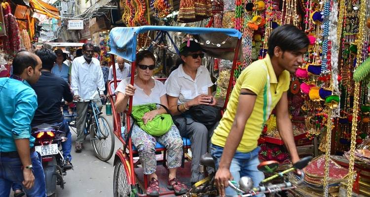 Drukke straatmarkt met riksja's en decoratieve items.