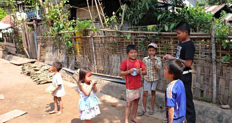 Group of children playing outdoors in a village setting.