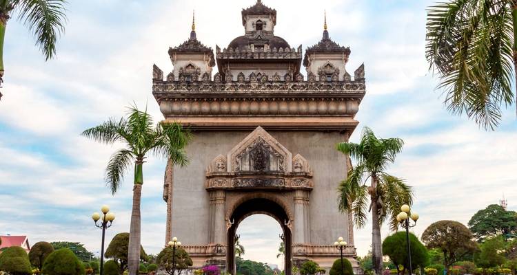 Patuxai monument in Vientiane surrounded by palm trees.