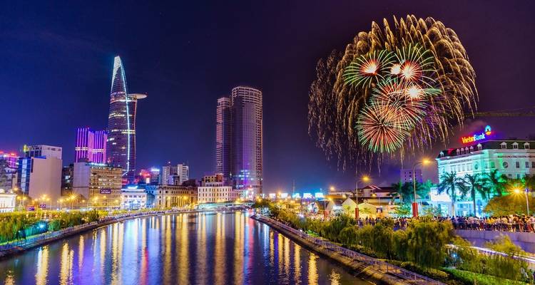 Nighttime skyline with fireworks over river