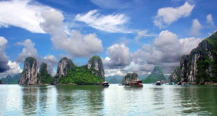 Wolken über Kalkstein-Karst und Boote auf dem Wasser